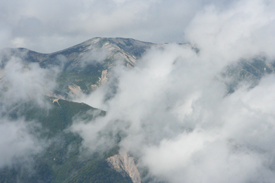 雲間から姿を現した野口五郎岳の写真