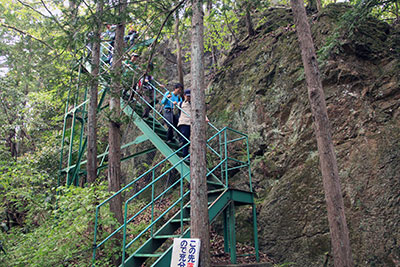 岩の横の急な階段を下っている写真