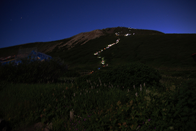 御前峰に続くヘッドランプの灯りの写真