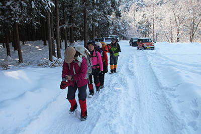 滝尾神社の少し上から雪道の林道を歩いている写真