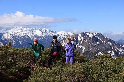青空の下で焼岳、乗鞍岳を背に登ってきたメンバーの写真