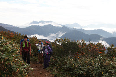 谷川連峰方面を背に立つメンバーの写真