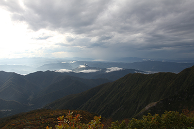 日本海側が黒い雲で、左手側（上州側）はうすい雲になっている写真