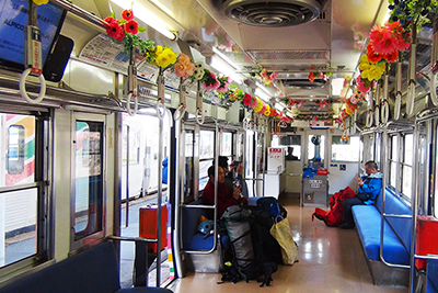 きれいに造花が飾られた松本電鉄車内の写真
