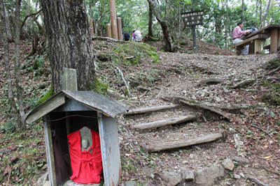 赤い服を着た地蔵のある地蔵峠を通過している写真
