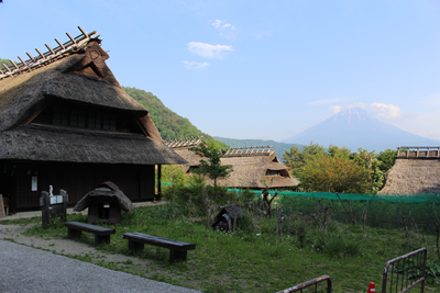 かやぶき屋根の家と富士山の写真