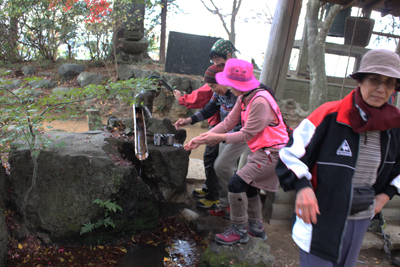 弘法山の手押しポンプで水を出し、手を洗っている写真