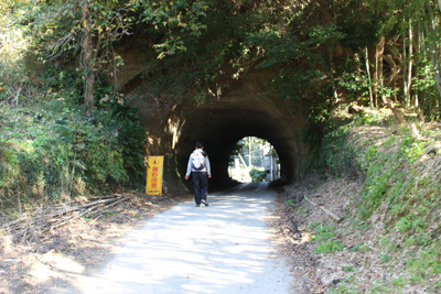 手彫りのトンネルに入ろうとしているMIさんの写真