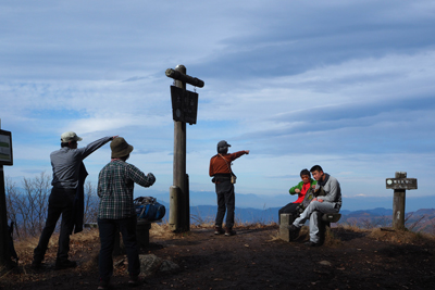 Iさんが撮影した山頂で山を見ているメンバーの写真