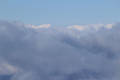 雲間から見える真っ白な槍穂高連峰の写真