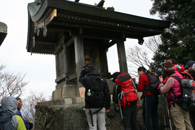男体山の山頂の祠にお参りしている写真