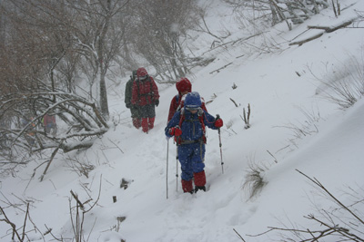 すっかり吹雪となった中を登っている写真