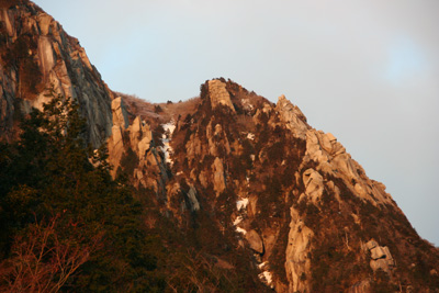 朝日に染まった藤内壁前尾根と中尾根の写真