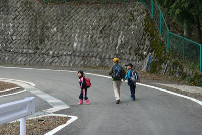 小学生の手をつないで歩く中１のKI君の写真