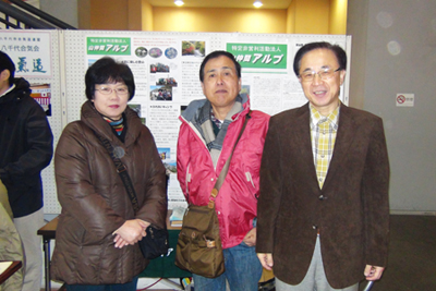 山仲間アルプのブースの前での３人の写真
