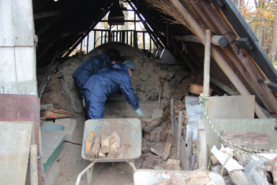 炭焼き小屋で炭焼きの準備をしている人の写真