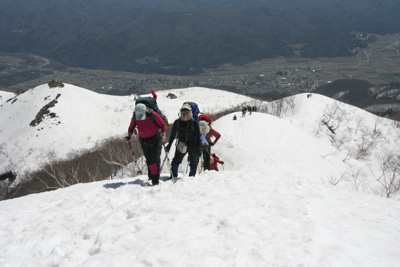 すばらしい天気の下で雪の尾根を登っている写真