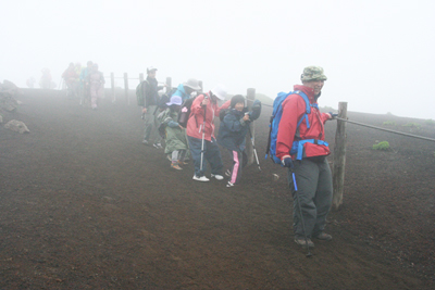 富士山のような火山岩の砂礫地を下っている写真