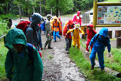登山口の一の鳥居を雨具を着て出発した写真