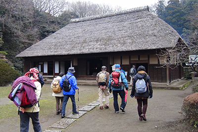 新林公園内の古民家の庭を歩いている写真
