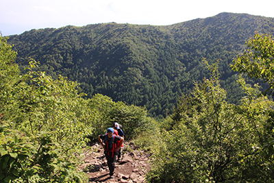 烏帽子岳を背に湯ノ丸山に登っている写真