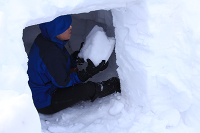 掘り出した雪を出しているTさんの写真