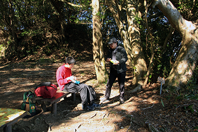 高塚山山頂のベンチに座っているM君とMさんの写真