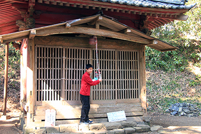 山頂のお堂をお参りしているM君の写真