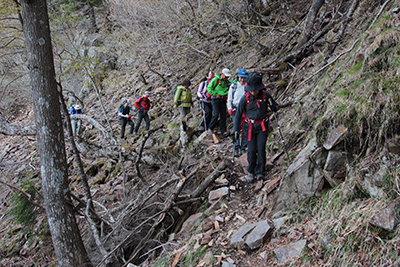 右側が切れている登山道を歩いている写真