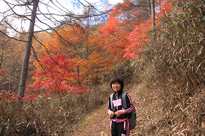 きれいに紅葉した木を背にしたＫちゃんの写真