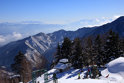合戦小屋で休憩する人たちと八ヶ岳、富士山、南アルプス方面の写真