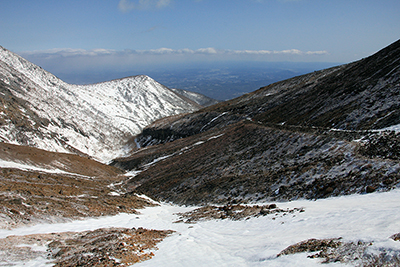 峰の茶屋跡避難小屋付近から振り返ってみた登山道と麓の写真