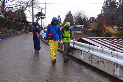 舗装道路を手をつないで歩くＫさんとＭ君の写真
