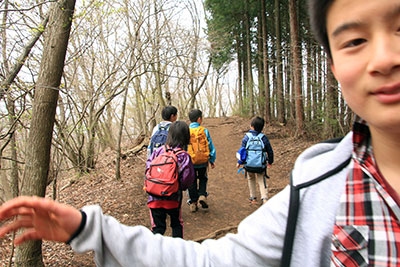 カメラの前に立つＭ君と子どもたちの後ろ姿の写真