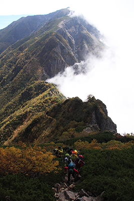 聖岳から兎岳に続く越えてきた稜線を背に兎岳に登っている写真
