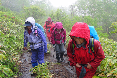 雨が降ってきたので雨具を付けて登っている写真