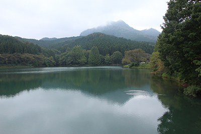 赤川ダム湖と山頂を雲に隠した古賀志山の写真