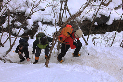 雪の山道を登っている写真