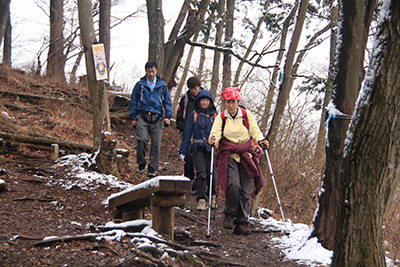 雪の少なくなった登山道を下っている写真