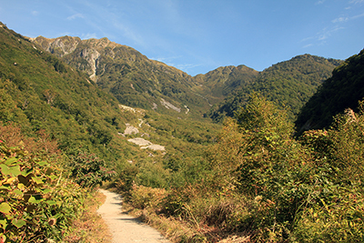 小池新道の登山口付近から見た大ノマ岳、弓折岳、鏡平方面の写真
