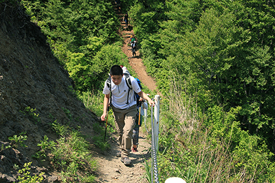 米山山頂に向けて鎖の張られた尾根を登っている写真