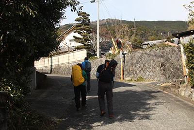 舗装道路を上っている後ろ姿の写真