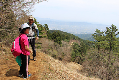 麓の見える登山道に立つKちゃんとCさんの写真