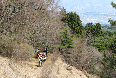 麓の町が見える登山道を登っている写真