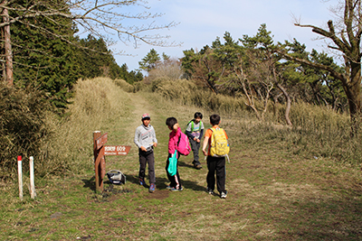 明星ヶ岳と宮城野の分岐の道標の前に立つ子どもたち４人の写真
