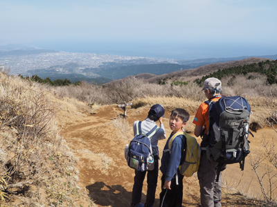 Iさんが撮影した明神ヶ岳山頂から下り、相模湾の見えるところに立つMくんとYくんとAさんの写真