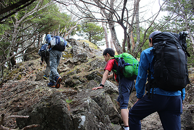 山頂直下の岩場を登っている写真