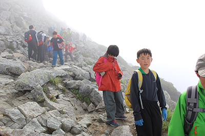 岩の多い雄山からの道を下っている写真