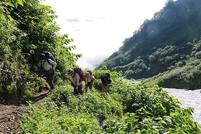 鑓温泉の上の登山道を登っている写真