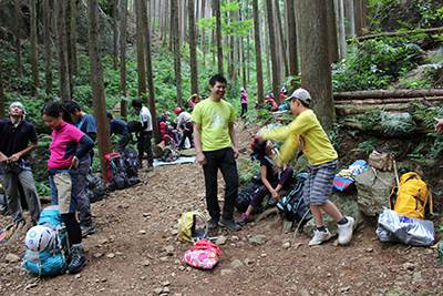 大勢の人が登山道脇で休憩している写真